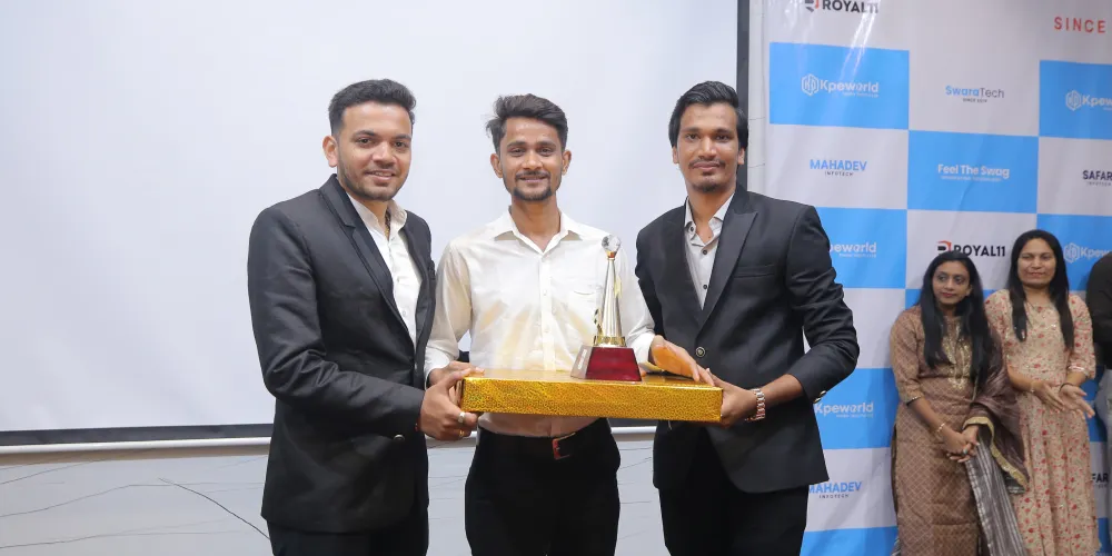 Three team members holding an award trophy