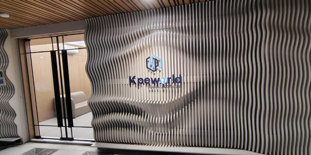 Kpeworld reception with the logo on a sculpted wooden wall